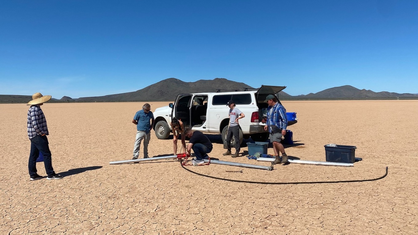 Field crew standing in front of white truck in the desert