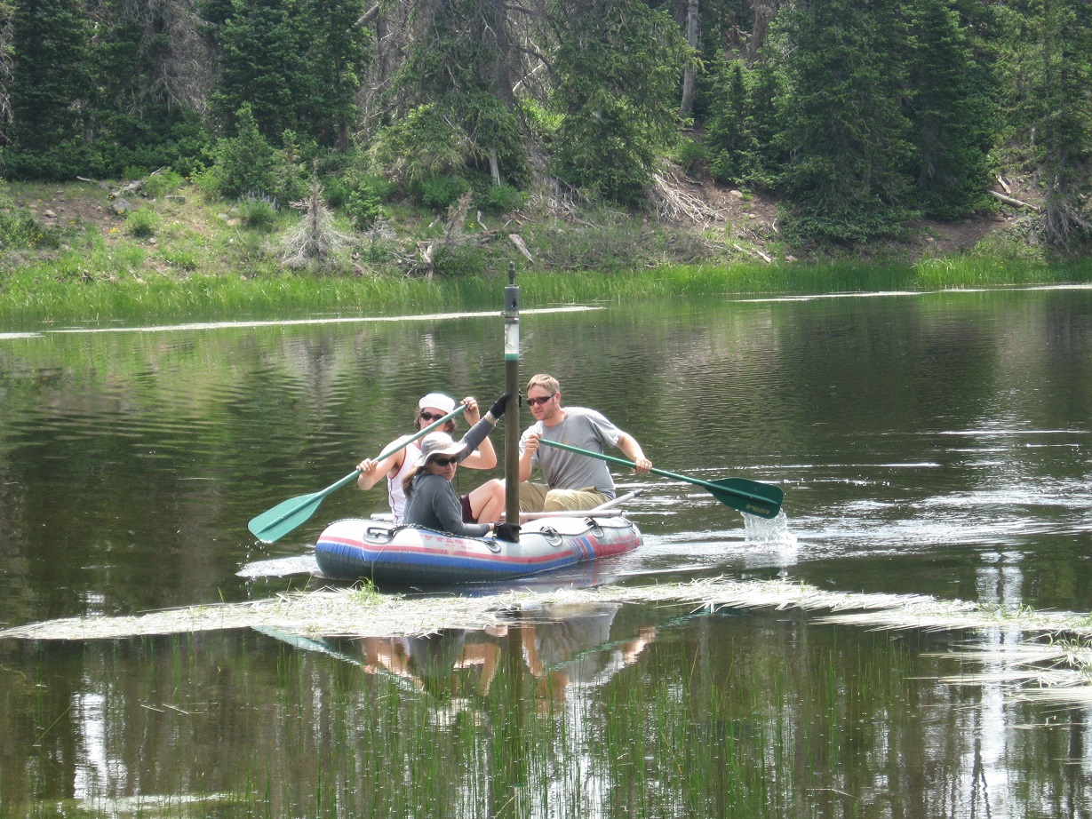 Three people on boat with sediment core equipment