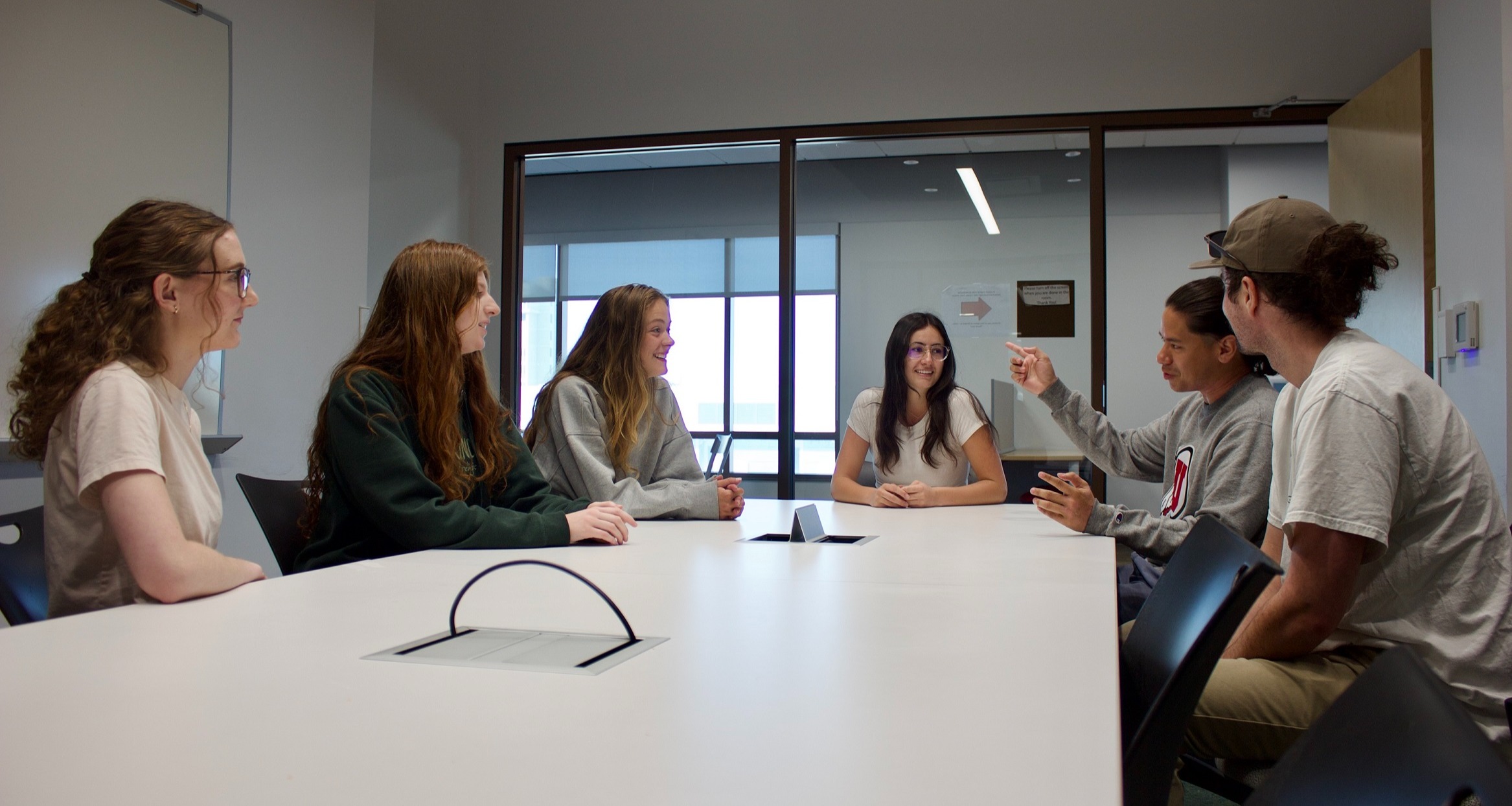 Students sit around a table and discuss sustainability education topics